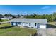 Light blue house with gray roof, two windows, and a garage at 282 Seminole Nw Blvd, Port Charlotte, FL 33952