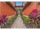 Landscaped entryway to condo building with brick walkway at 3500 Mondovi Ct # 212, Punta Gorda, FL 33950