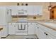 White kitchen with range, microwave, and granite countertops at 3500 Mondovi Ct # 212, Punta Gorda, FL 33950