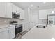 Modern kitchen with white cabinets, quartz countertops, and stainless steel appliances at 4024 Feather Ter, North Port, FL 34286