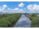 Serene canal view, lush greenery, blue skies at 4118 Gardner Dr, Port Charlotte, FL 33952