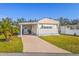 Tan single wide home with carport and landscaping at 5298 Palena Blvd, North Port, FL 34287