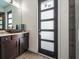 Modern bathroom with dark brown vanity, vessel sink, and frosted glass door at 5870 Hornbuckle Blvd, North Port, FL 34291