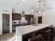 Modern kitchen featuring dark wood cabinets, quartz countertops, and a large island at 5870 Hornbuckle Blvd, North Port, FL 34291