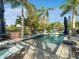 Inviting pool area with lounge chairs, palm trees, and a basketball hoop at 5870 Hornbuckle Blvd, North Port, FL 34291