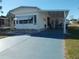 Mobile home with covered porch and a paved driveway at 6815 Amoko Ct, North Port, FL 34287