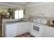 Galley style kitchen with white cabinets and appliances at 6815 Amoko Ct, North Port, FL 34287