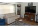 Living room with off-white couch and wood entertainment center at 6815 Amoko Ct, North Port, FL 34287