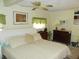 Main bedroom with king bed, dresser, and ceiling fan at 6815 Amoko Ct, North Port, FL 34287