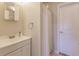 Clean bathroom with white vanity, shower, and mirror at 701 Coral Way, Englewood, FL 34223