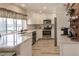 Updated kitchen featuring white cabinets, stainless steel appliances, and a wood accent wall at 701 Coral Way, Englewood, FL 34223