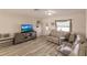 Living room with light colored sectional sofa and wood-look floors at 701 Coral Way, Englewood, FL 34223