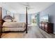 Main bedroom with post bed, hardwood floors, and pool view at 1131 Via Tripoli, Punta Gorda, FL 33950