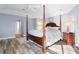 Main bedroom with post bed, hardwood floors, and access to bathroom at 1131 Via Tripoli, Punta Gorda, FL 33950
