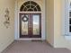 Front entry featuring double doors with glass inserts and a welcome mat at 1131 Via Tripoli, Punta Gorda, FL 33950