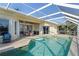 Inviting pool area with covered patio, lush landscaping, and canal views at 1131 Via Tripoli, Punta Gorda, FL 33950