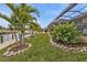 Well manicured canal front lawn with tropical plants at 1220 Spanish Cay Ln, Punta Gorda, FL 33950