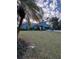 Gray house with teal accents, lush lawn, and palm trees at 1281 Nebraska Ln, North Port, FL 34286