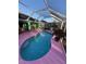 Relaxing kidney-shaped pool with pink deck and screened enclosure at 1281 Nebraska Ln, North Port, FL 34286