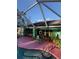 Inviting kidney-shaped pool with pink deck and screened enclosure at 1281 Nebraska Ln, North Port, FL 34286