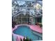 Kidney-shaped pool with pink deck and screened enclosure at 1281 Nebraska Ln, North Port, FL 34286