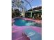 Serene kidney-shaped pool with pink deck and screened enclosure at 1281 Nebraska Ln, North Port, FL 34286