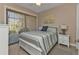 Cozy bedroom with striped bedding and access to a screened lanai at 143 Uruguay Dr, Punta Gorda, FL 33983