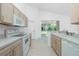 Modern kitchen with light wood cabinets and sliding door to backyard at 1434 Hedgewood Cir, North Port, FL 34288