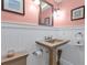 Small bathroom with pedestal sink and beadboard wainscot at 162 Croop Se Ln, Port Charlotte, FL 33952