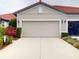 Attractive two-car garage with light colored door and landscaping at 2522 Thyme Way, North Port, FL 34289