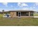 Tan house exterior with a screened porch and spacious yard at 30087 Alder Rd, Punta Gorda, FL 33982