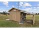 Tan wooden storage shed with covered workspace at 30087 Alder Rd, Punta Gorda, FL 33982
