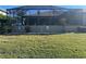 Landscaped backyard with screened enclosure at 3761 Peace River Dr, Punta Gorda, FL 33983