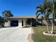 Single-story home with a two-car garage and landscaped yard at 3761 Peace River Dr, Punta Gorda, FL 33983