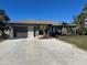 Single-story home with a two-car garage and palm trees at 3761 Peace River Dr, Punta Gorda, FL 33983