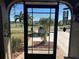 View of the front entry with a screened door and garden at 3761 Peace River Dr, Punta Gorda, FL 33983