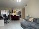 Open living room features a gray sectional sofa and a view into the kitchen at 3761 Peace River Dr, Punta Gorda, FL 33983