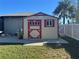 Tan and red storage shed with window and door at 3761 Peace River Dr, Punta Gorda, FL 33983