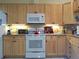 Kitchen with white appliances and wood cabinets at 3830 Bal Harbor Blvd # 17, Punta Gorda, FL 33950