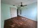 A bedroom with light green walls, ceiling fan, and wood-look tile floor at 420 Sailfish Ln, Punta Gorda, FL 33982