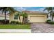 Beautiful yellow house with a brick driveway and landscaping at 6139 Grand Cypress Blvd, North Port, FL 34287