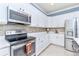 Bright kitchen boasts stainless steel appliances and white cabinetry at 6139 Grand Cypress Blvd, North Port, FL 34287