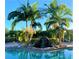 Relaxing pool area with waterfall, palm trees, and comfortable seating at 6139 Grand Cypress Blvd, North Port, FL 34287