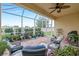 Enjoy this screened patio with ceiling fan, comfortable seating, and access to backyard at 6139 Grand Cypress Blvd, North Port, FL 34287