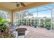 Relaxing screened patio with brick pavers, wicker furniture, and lush landscaping at 6139 Grand Cypress Blvd, North Port, FL 34287