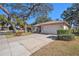 Single-story home with a two-car garage and landscaped yard at 10810 Cedar Breaks Dr, Port Richey, FL 34668