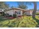 Single-story home exterior showcasing a landscaped yard with mature trees at 10810 Cedar Breaks Dr, Port Richey, FL 34668