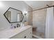 Bathroom with walk-in shower, modern vanity, and hexagon mirror at 11346 Laffite Pl, Port Charlotte, FL 33981