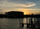 Stunning sunset over calm water with building silhouette and dock at 1217 Aqui Esta Dr # 5, Punta Gorda, FL 33950