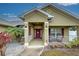 Front entryway with a covered porch and maroon door at 13536 Ainsworth Ln, Port Charlotte, FL 33981